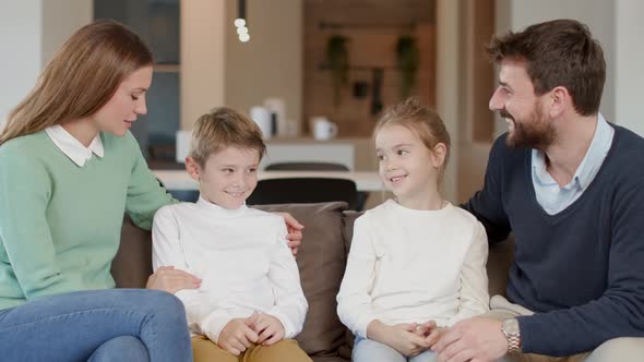 Happy family with two kids enjoy time together on couch in living room