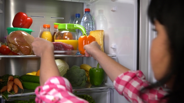 Woman Takes Meat From Refrigerator