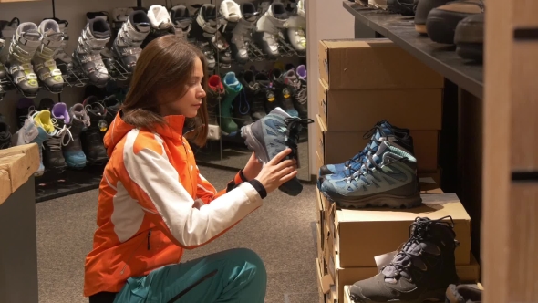 Woman Looks at Sports Shoes in a Store