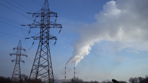 Power Lines and Pipe Smoke Power Plant Against Blue Sky.