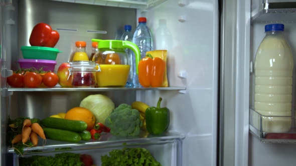 Woman Puts Eggs in Refrigerator