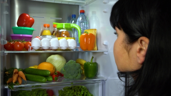 Woman Takes Eggs From Refrigerator