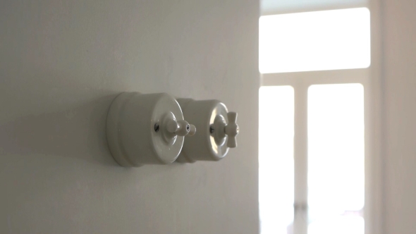 A Man Hand Turning on and Off a Light Switch in a House