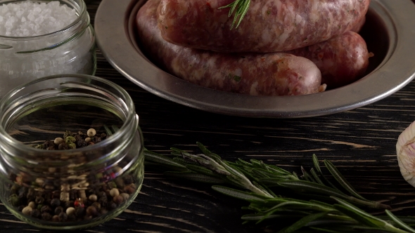 Raw Sausages with Garlic, Rosemary on Wooden Surface