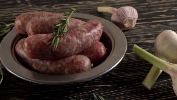 Raw Sausages with Garlic, Rosemary on Wooden Surface