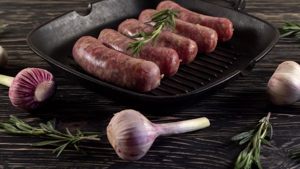 Raw Sausages with Garlic, Rosemary on Wooden Surface