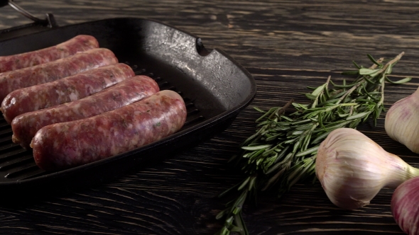 Raw Sausages with Garlic, Rosemary on Wooden Surface