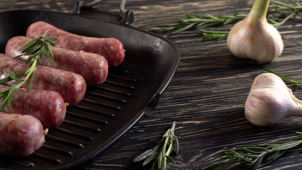 Raw Sausages with Garlic, Rosemary on Wooden Surface