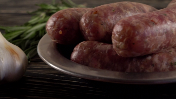 Raw Sausages with Garlic, Rosemary on Wooden Surface