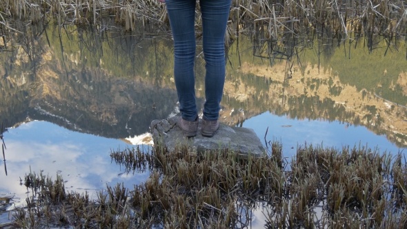 Woman Legs Stand at the Lake with Reflecting Water