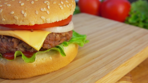 Hamburger with Cheese and Tomatoes on the Table alt