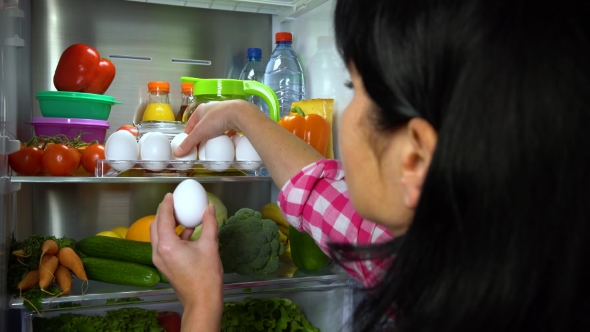 Woman Takes Eggs From Refrigerator