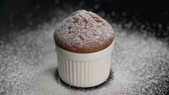 Muffin Cake with White Powdered Sugar on Dark Background. Blur Effect