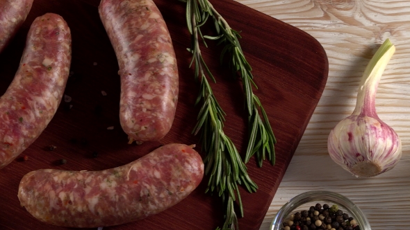 Raw Sausages with Garlic, Rosemary on Wooden Surface