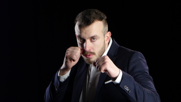 Sportsman in Business Suit Is Boxing, Looks at the Camera alt