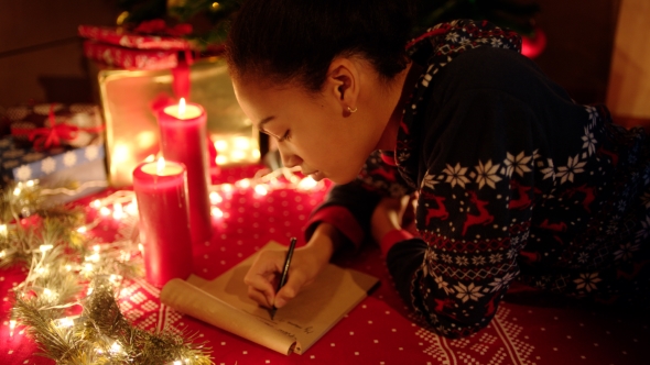 Teen Girl Is Lying and Writing a Letter To Santa Claus on New Years Eve alt