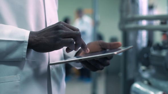 Cropped Scientist Hands Clicking Tablet in Lab alt