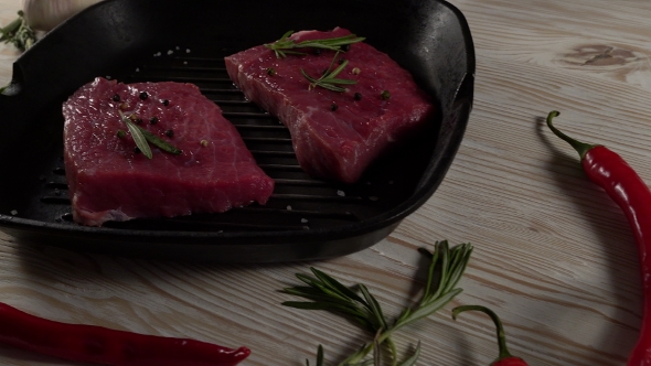 Beef Fillet on a Pan with Pepper, Rosemary, Axe and Garlic.