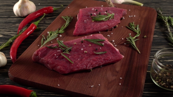 Beef Fillet on a Desk with Pepper, Rosemary and Garlic.