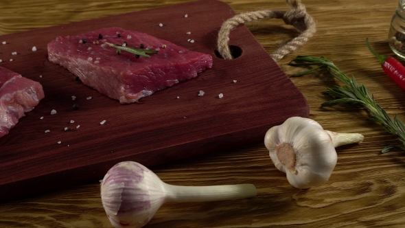 Beef Fillet on a Desk with Pepper, Rosemary and Garlic.