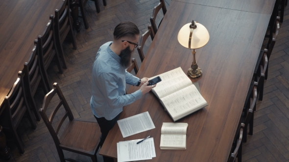 VideoHive Male Student with Open Book Working in a Library 19728436 VideoHive Male Student with Open Book Working in a Library 19728436