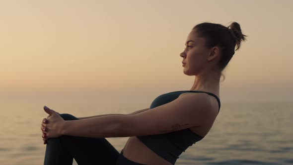 Sportswoman Raise Up Leg Holding Knee By Hands Outdoors alt