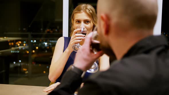 Couple toasting glass of wine while having dinner alt