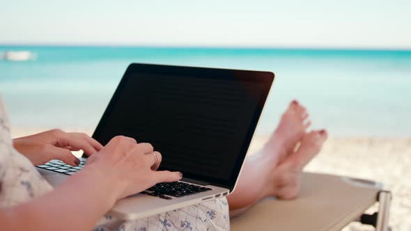 Business Woman Works Using Laptop on Sea Beach on Vacation in Summer