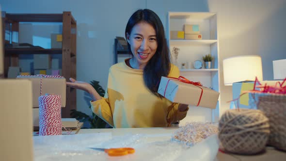 Happy young Asia businesswoman looking at camera selling  introduce product to client video live.