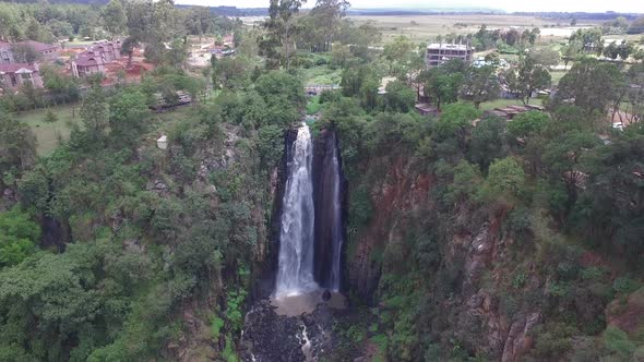 Aerial shot of buildings and a waterfall alt