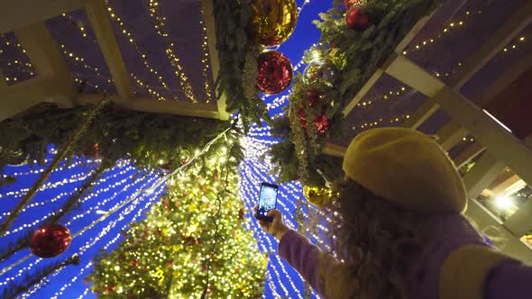 Lady in Beret Takes Picture of Christmas Tree at Winter Fair