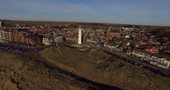 Drone Aerial Footage of Lighthouse and Cityscape at Sunset in Holland