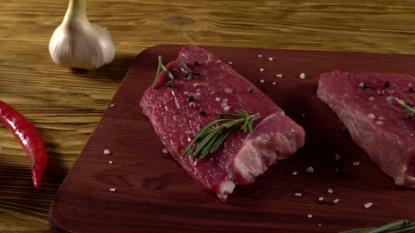 Beef Fillet on a Desk with Pepper, Rosemary and Garlic.