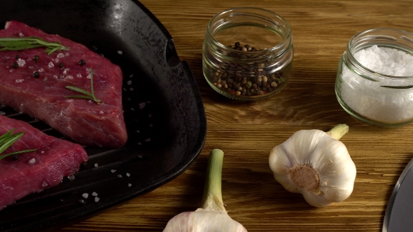 Beef Fillet on a Pan with Pepper, Rosemary, Axe and Garlic.