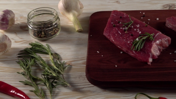 Beef Fillet on a Desk with Pepper, Rosemary and Garlic.