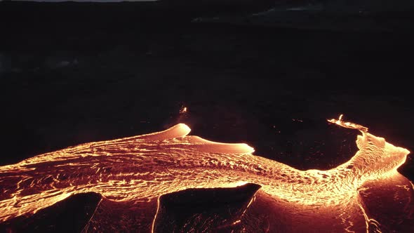 Drone Towards Flowing River Of Molten Lava In Black Landscape alt