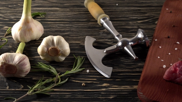 Beef Fillet on a Desk with Pepper, Rosemary Axe and Garlic.