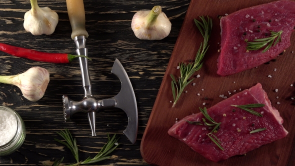 Beef Fillet on a Desk with Pepper, Rosemary Axe and Garlic.