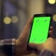 Woman Is Holding Smartphone with Green Screen in Cafe - VideoHive Item for Sale