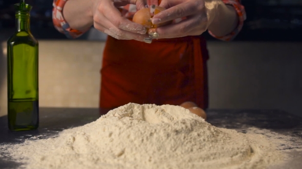 Cook Throw an Egg on a Pile of Flour In the Kitchen of a Pizzeria