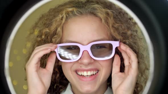 Portrait of a Teenage Girl Wearing Sunglasses Looking in the Mirror