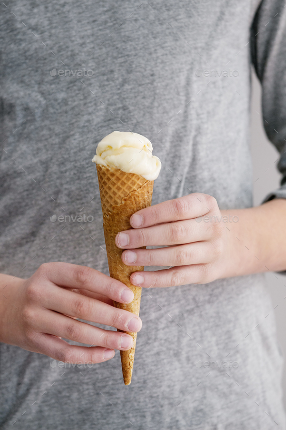 Ice cream in waffle cane in boy\'s hands
