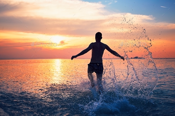 Man running into the sea - Stock Photo - Images