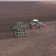 The Tractor Draws an Agricultural Device for Harrowing the Land Spring Work in the Field, Aerial - VideoHive Item for Sale