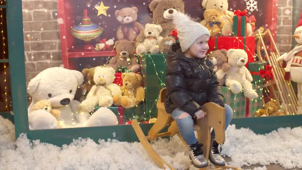 Happy Child Riding Rocking Horse Near Toy Shop