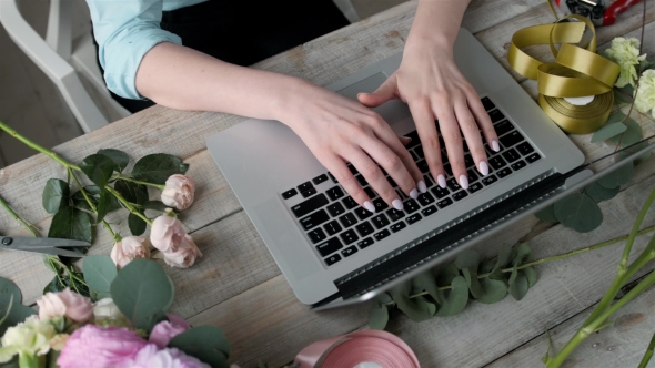 Office Workplace Essentials: Laptop, Paper Notebook, Bouquet of Flowers on the Rustic Wooden Table alt