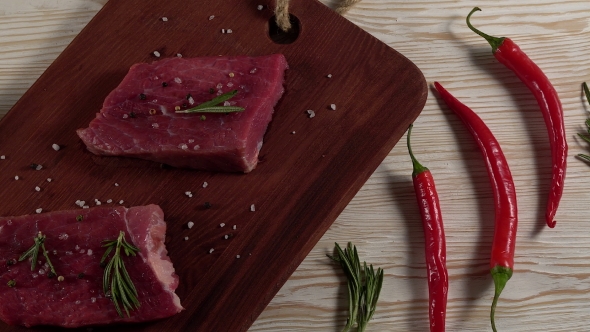 Beef Fillet on a Desk with Pepper, Rosemary and Garlic.