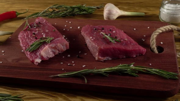 Beef Fillet on a Desk with Pepper, Rosemary and Garlic.