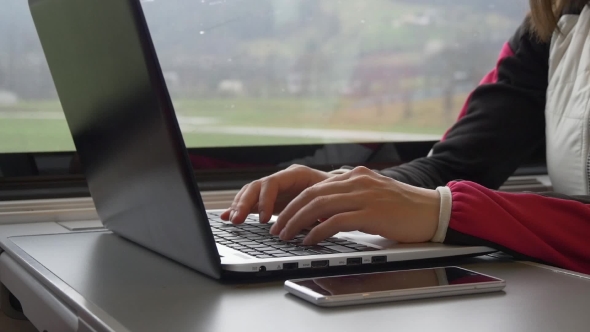 Woman Typing on Laptop Keyboard in Train