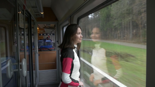 Woman Looks Out the Window in a Train and Smiles